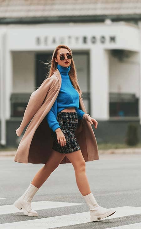Girl sunglasses skirt sweater walks street