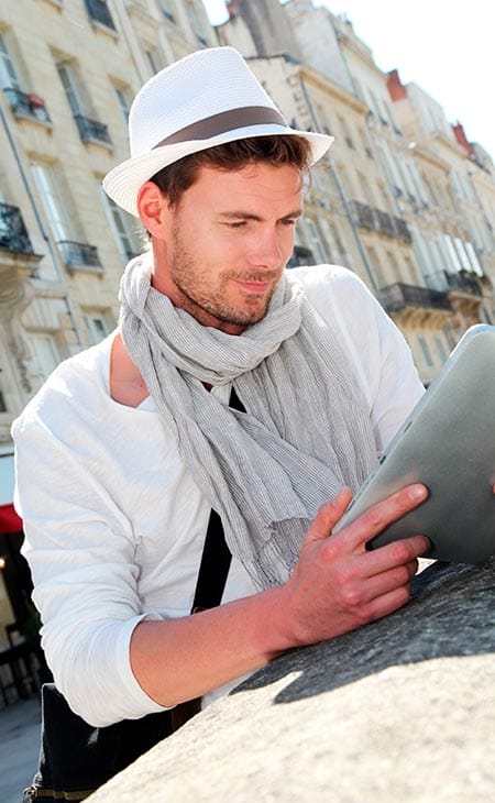 Man looking tablet outdoors panama hat