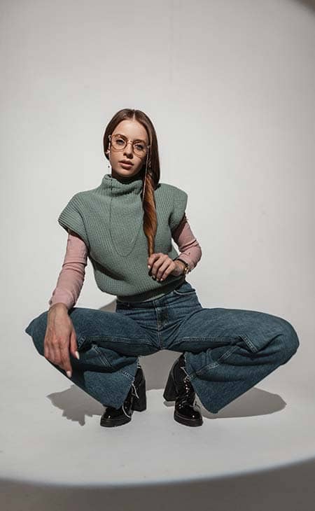 Woman posing sit glasses sweater wide leg flared jeans