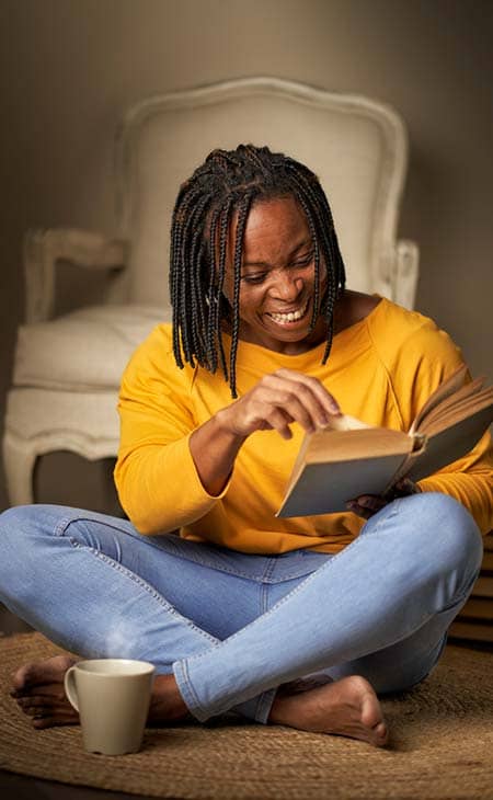 Smiling african american woman reading book