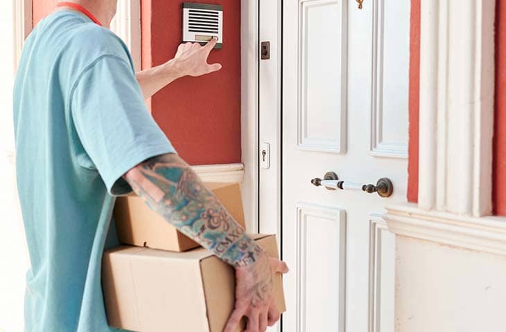 Man delivering package door doorbell