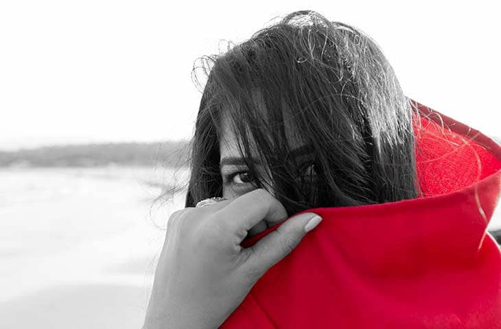 Woman covering face red coat