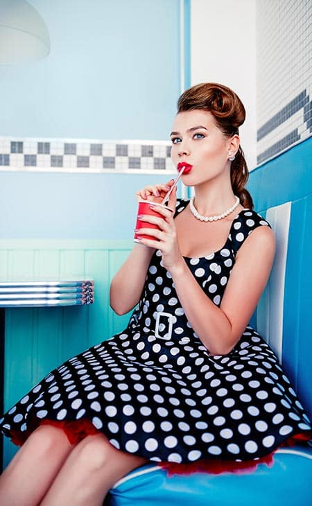 Woman sips milkshake 50s look