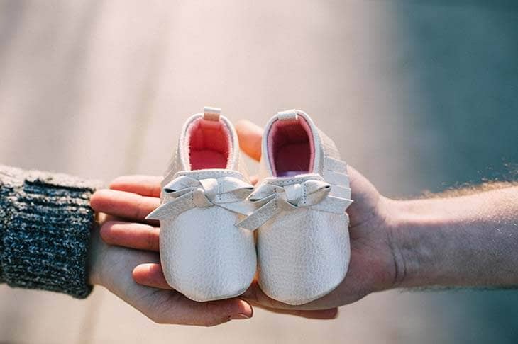 Hands holding baby shoes