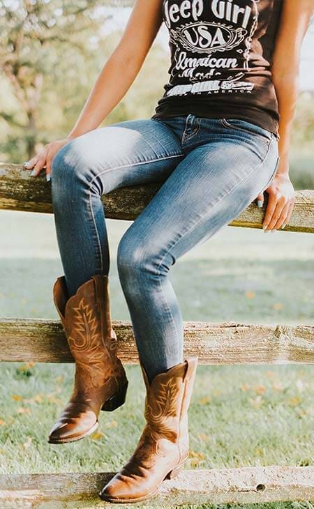 Woman sitting fence cowboy boots
