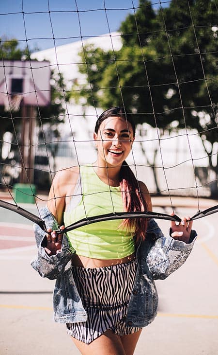 Woman smiles holding tennins net