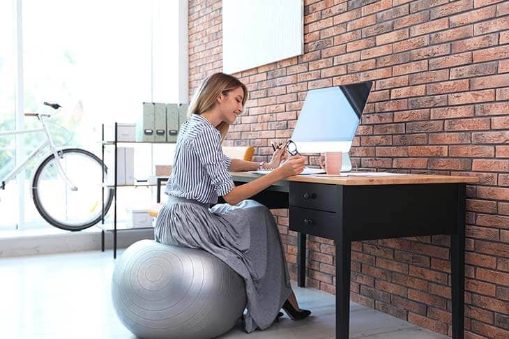 Businesswoman sitting on fitness ball office