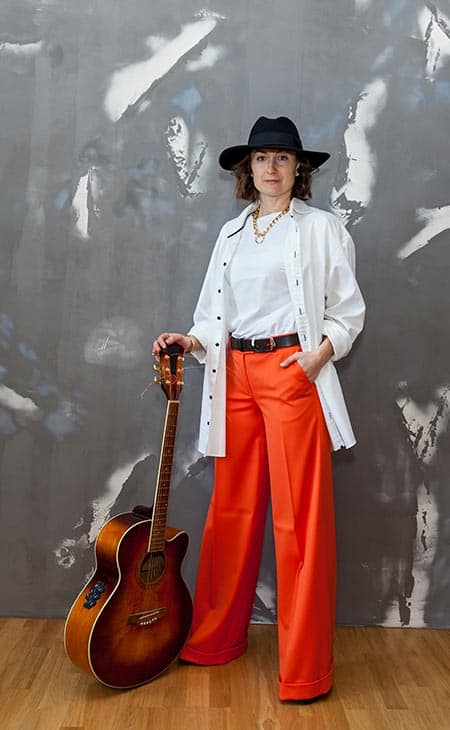 Woman posing holds guitar hat