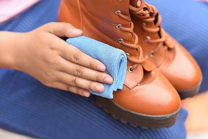 Cleaning leather shoes with a polishing cloth premium photo