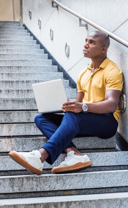 Man sitting stairs laptop