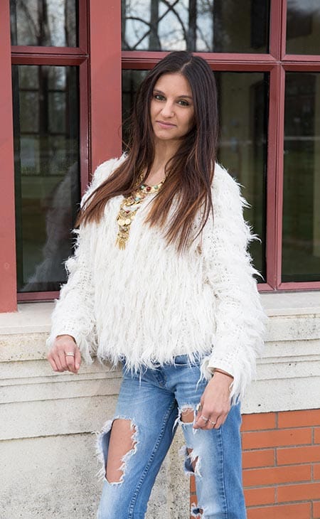 Woman poses smiling fur jacket jeans