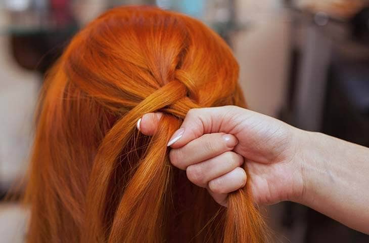 Redhead woman hand braids