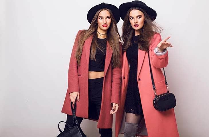 Two women casual coat hat handbag