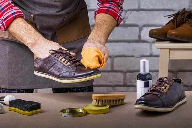 Man hands cleaning shoes