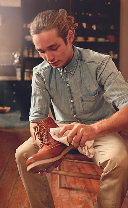 Man seated cleaning shoes