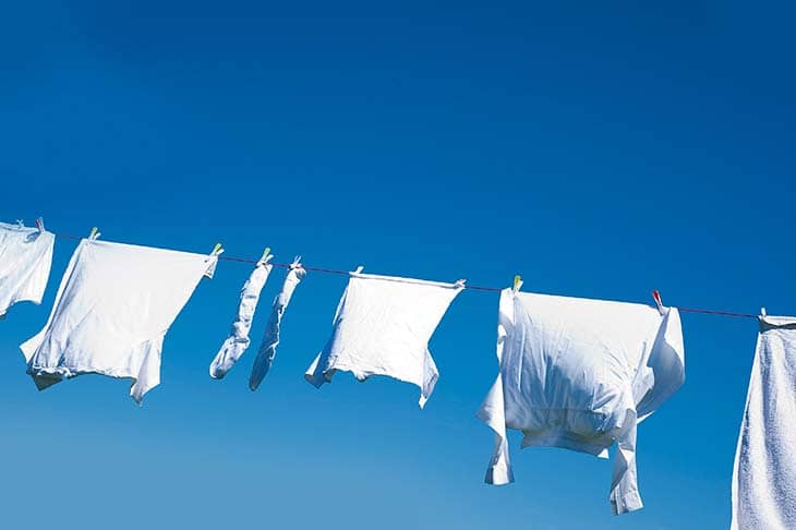 White clothes hanging line sky