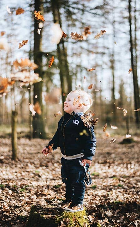 Little-kid-forest-autumn-leaves