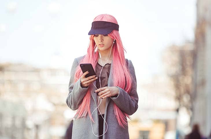 Woman looking phone pink hair
