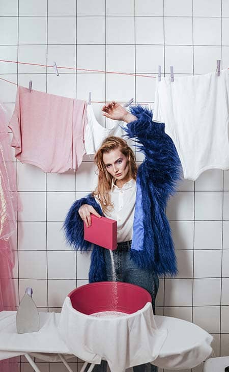 Woman fur coat washing clothes bathroom