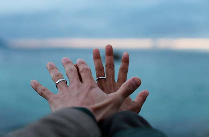 Hands rings stretched out towards ocean
