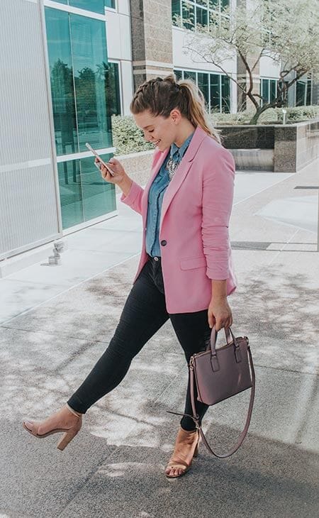 Woman pink blazer holding leather handbag
