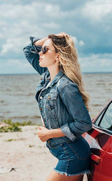 Woman posing jeans sunglasses car