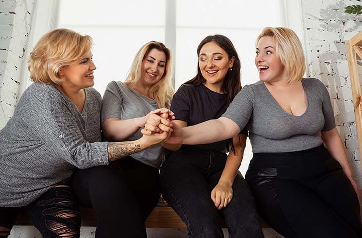Group women smiling holding hands