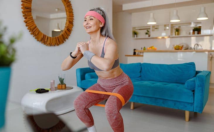 Sporty woman using resistance band home workout