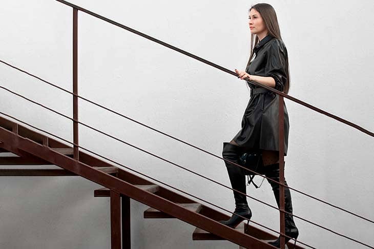 Woman black dress black boots stairs
