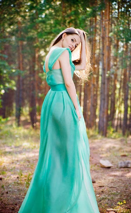 Woman holding head mint dress forest