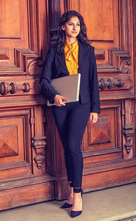 Woman black blazer orange shirt carrying laptop