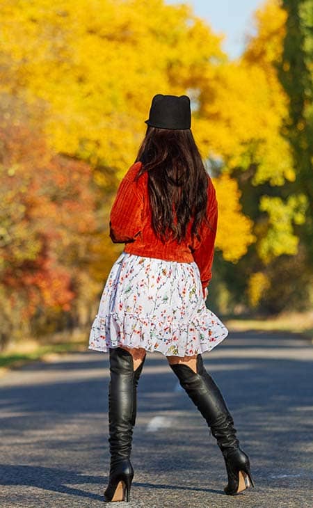 Woman from behind high boots stand road