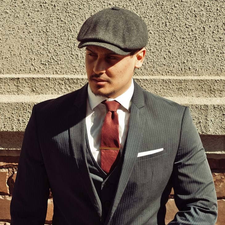 1920s man wearing dark suit flat cap