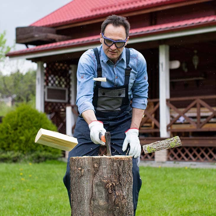 Man sawdust chopping wood pieces overalls