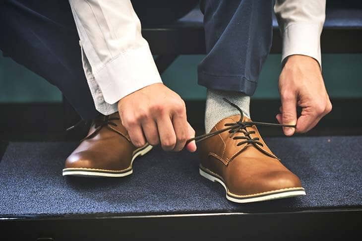 Man hands tying shoes