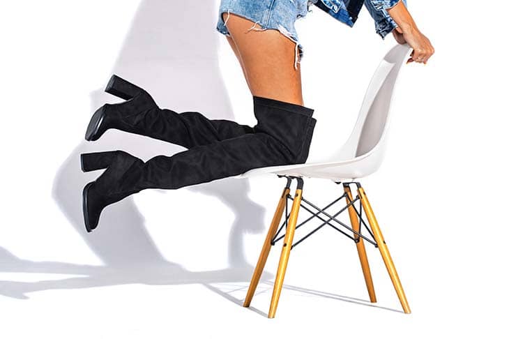 Woman legs denim shorts chair black boots knees