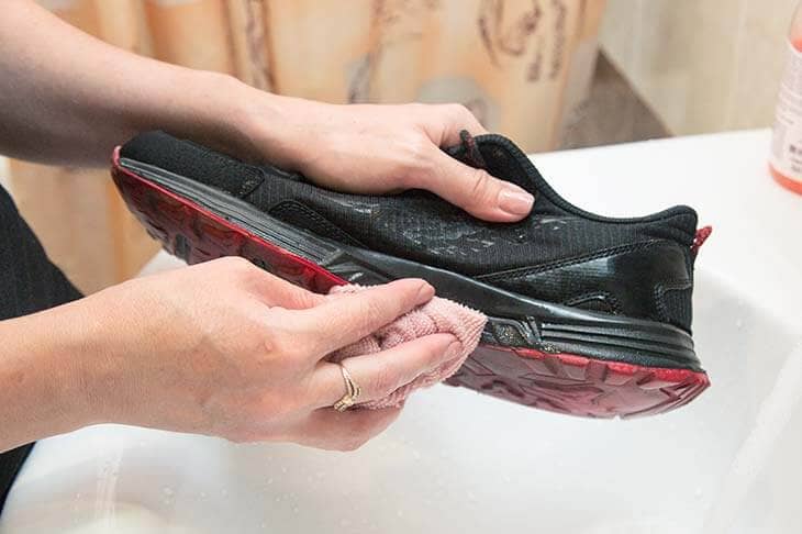 Woman bathroom washes sneakers water