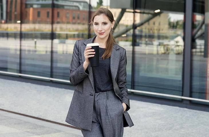 Woman business suit outdoors office building drinks coffee